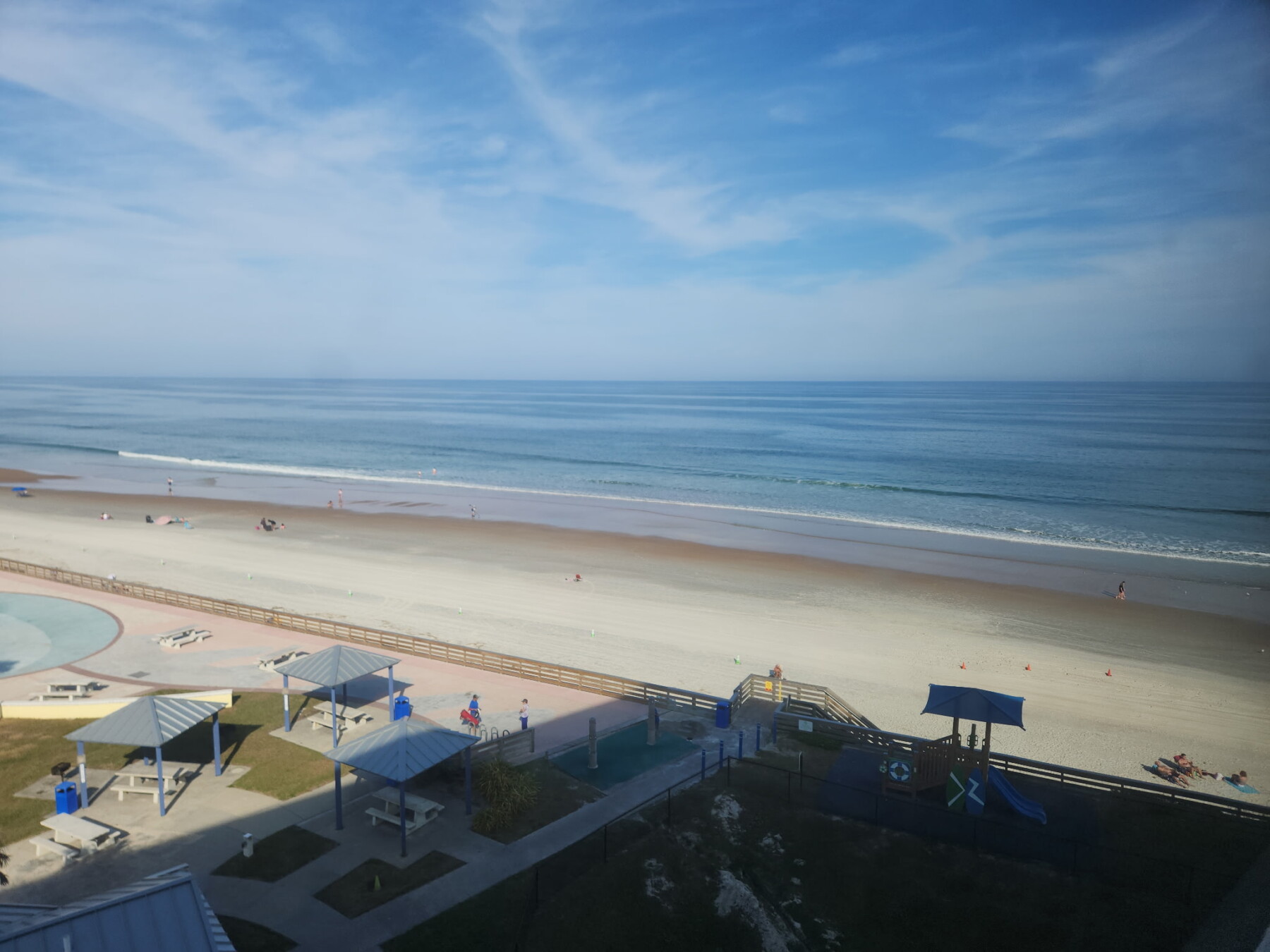 View from our window. In the shadow of the picture in an umbrella and that is a playscape for the kids next door. Over to the left a bit in the sun is the splash park for th kids to play in the water spouts